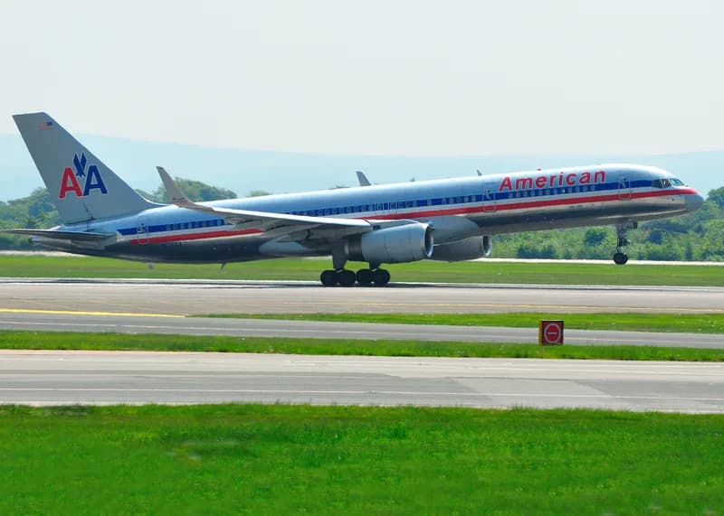 An American Airlines jet parked at a boarding gate