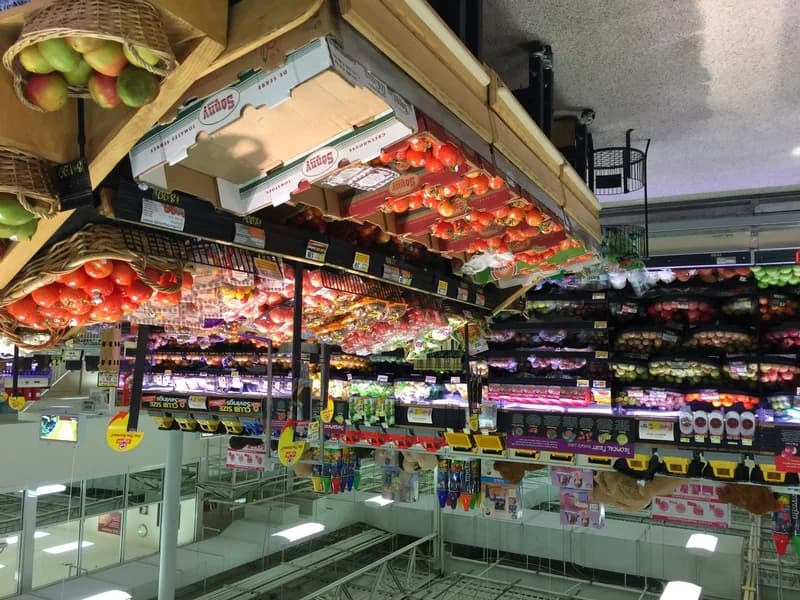 Shopper choosing mangoes at a Walmart produce display