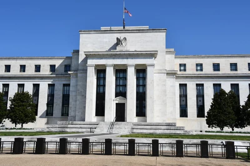 The exterior of the Federal Reserve building in Washington seen through summer trees