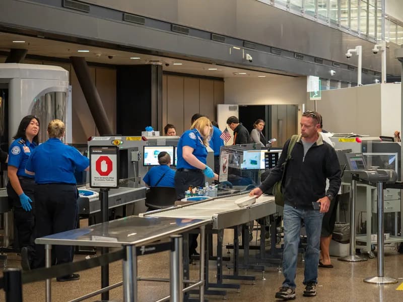 Passengers saying goodbye at an airport security line